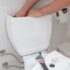 Man using hands repairing toilet cistern